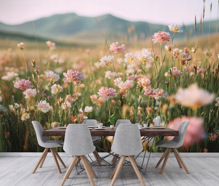 Esszimmertischgruppe vor einer Fototapete mit einer Blumenwiese und Bergen in einer hellen Wohnumgebung.