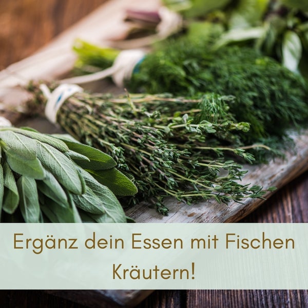 Mehrere Kräuterbunde liegen auf einem Holzbrett.