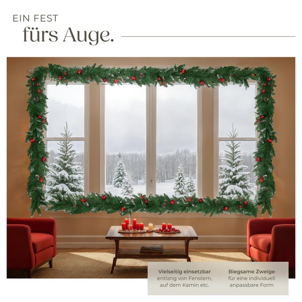 Weihnachtsdekoration mit Girlande, roten Kugeln und Tannenzapfen über einem Fenster
