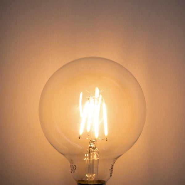 Eingeschaltete LED-Filament-Globe-Lampe mit warmweißem Licht.
