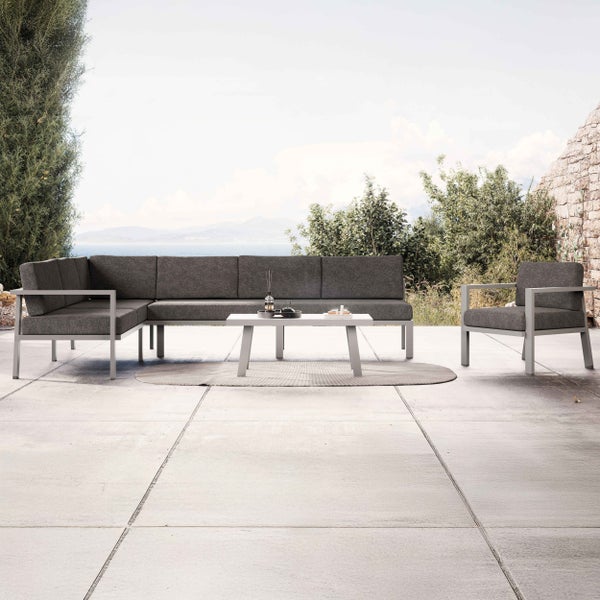 Moderne Gartenlounge aus Aluminium mit Ecksofa, Sessel und Couchtisch auf einer Terrasse mit Meerblick.