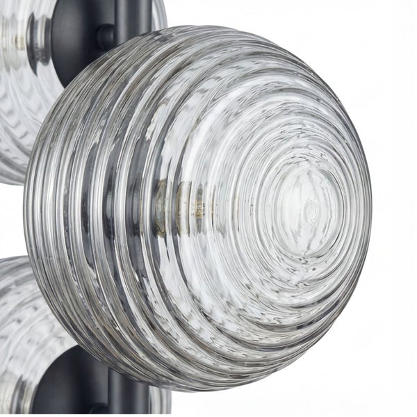 Nahaufnahme eines gerippten runden Lampenschirms aus Glas mit schwarzer Metallhalterung.