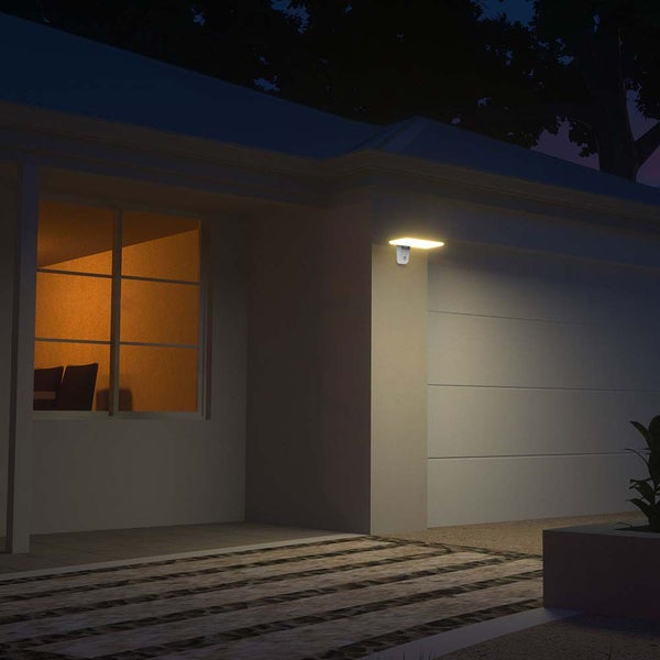 Außenansicht eines Hauses mit beleuchteter Außenwandleuchte am Abend