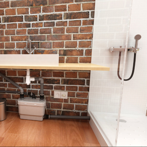 Hebeanlage für Schmutzwasser in einem Edelstahlunterschrank unter einer gewerblichen Spüle in einer Profiküche.