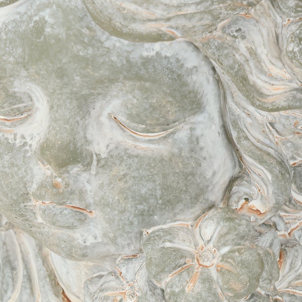 Detailaufnahme einer weiblichen Gesichtsskulptur aus Stein mit Blumendekor