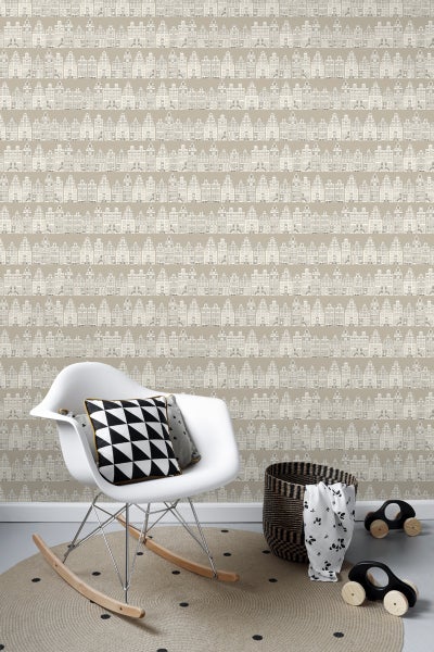 Kinderzimmer mit Tapete mit Häusermotiven, einem Schaukelstuhl, einem runden Teppich und Spielzeugautos.