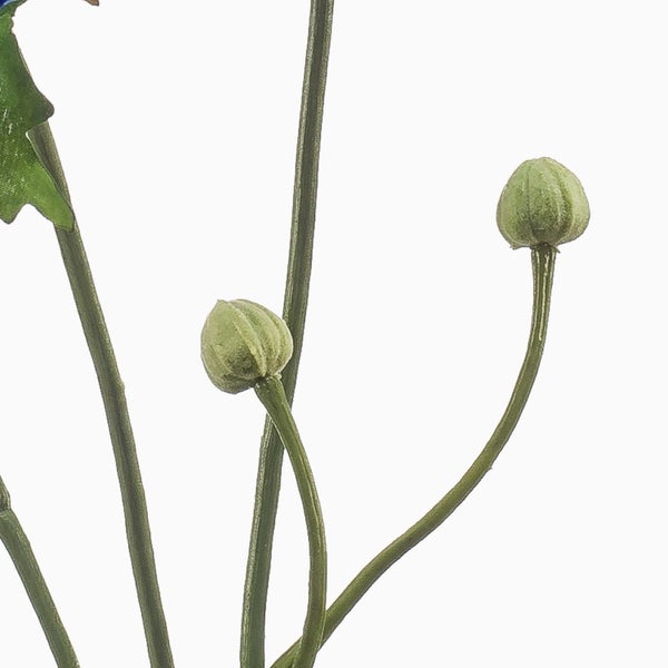 Detailansicht einer künstlichen Pflanze mit grünen Blütenknospen und Stielen