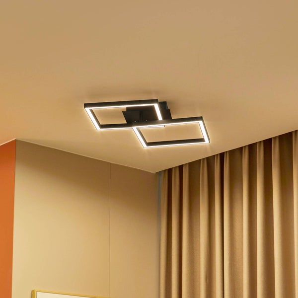 Moderne LED-Deckenleuchte mit zwei überlappenden schwarzen rechteckigen Rahmen an einer Zimmerdecke.