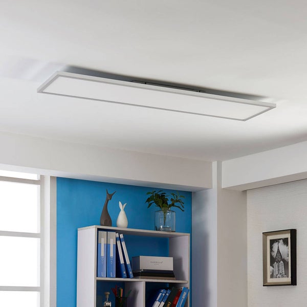 Rechteckiges LED-Panel an der Decke in einem hellen, modernen Raum über einem Bücherregal.