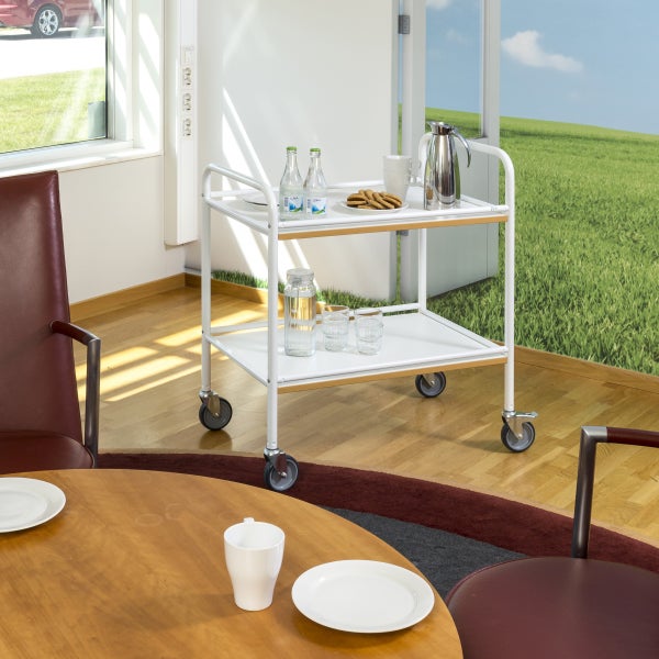 Servierwagen mit zwei Ebenen, Getränken und Geschirr in einem hellen Raum.