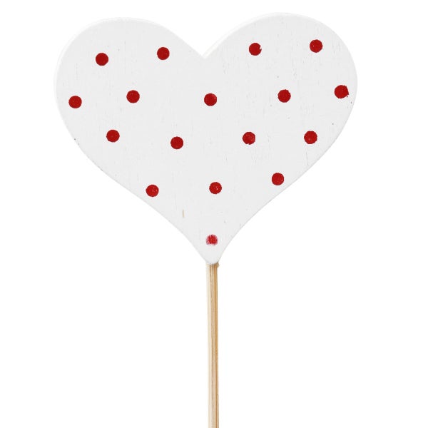 Herzförmige Dekoration mit Punktmuster auf Holzstab