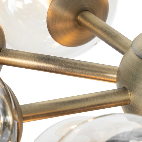 Nahaufnahme einer Deckenleuchte mit messingfarbenen Stangen und Glaskugeln