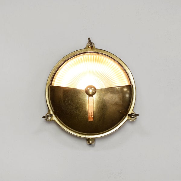 Runde Messing Wandleuchte mit eingeschaltetem Licht