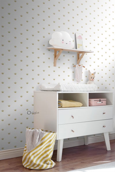 Babyzimmer mit Wickelkommode, Wandregal und Dekorationen vor einer mit Kronen bedruckten Tapete