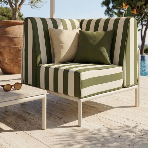Modernes Outdoor-Ecksessel-Modul mit grün-weiß gestreiften Polstern und zwei Zierkissen auf einer hellen Terrasse am Pool.