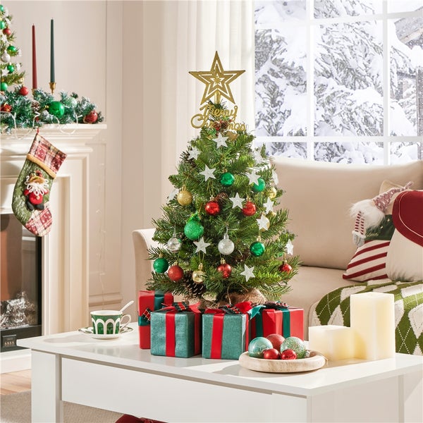 Dekorierter Weihnachtsbaum mit Geschenken auf einem Tisch in einem Wohnzimmer.