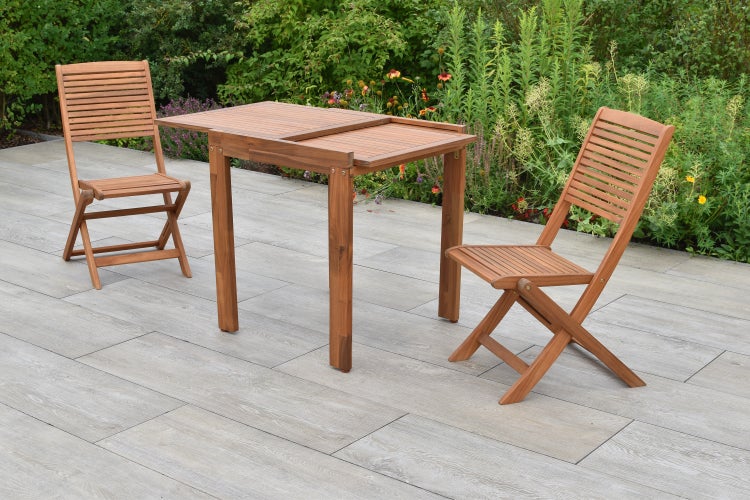 Gartenszene mit Holztisch und zwei Holzstühlen auf einer Terrasse