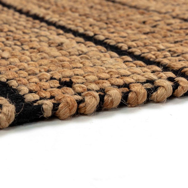 Nahaufnahme eines gewebten Teppichs aus Naturfasern mit schwarzem Streifenmuster.