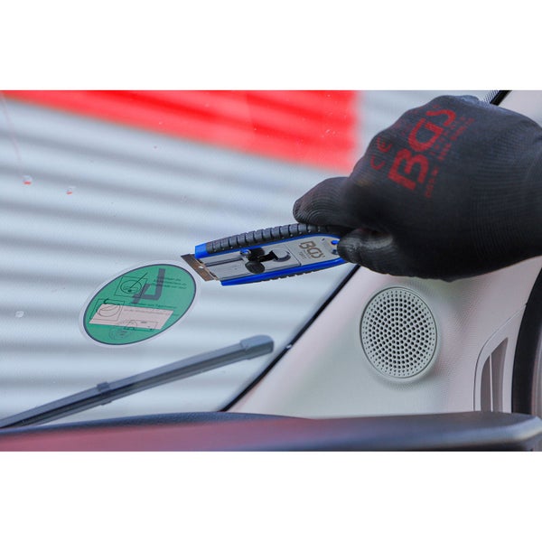 Blau-schwarzer Glasschaber mit zwei Ersatzklingen und ergonomischem Griff aus Kunststoff und Gummi.