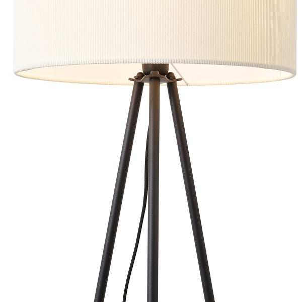 Dreibein-Stehleuchte mit weißem Stoffschirm und schwarzem Metallgestell.