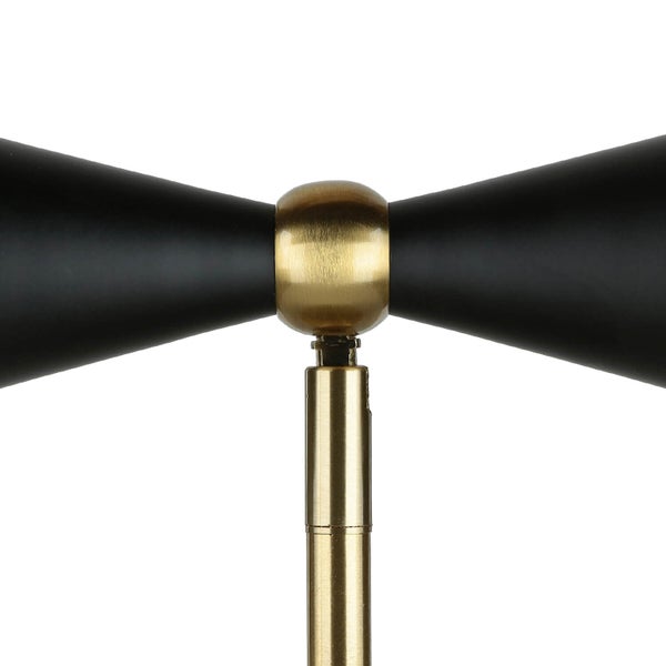 Detailaufnahme einer Stehlampe mit schwarzem Lampenschirm und goldenem Gestell