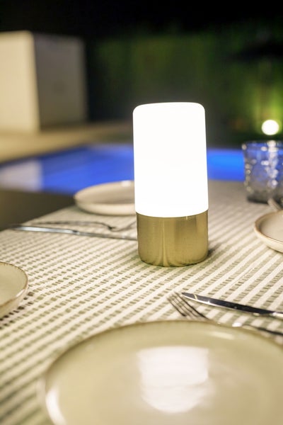 LED Tischleuchte fuer den Aussenbereich auf einem gedeckten Tisch im Garten