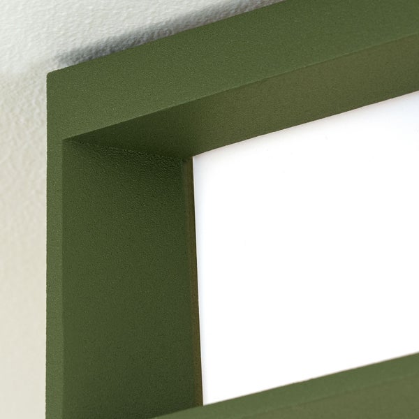 Detailansicht einer Wandleuchte oder Deckenleuchte mit strukturiertem grünem Rahmen und weißem Diffusor.
