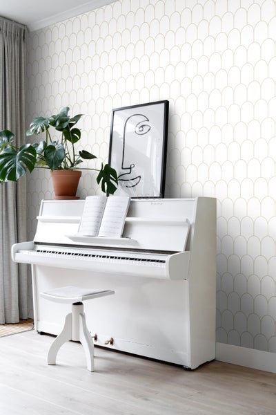 Helles Zimmer mit weißem Klavier, Stuhl, Zimmerpflanze und Tapete mit geometrischem Muster