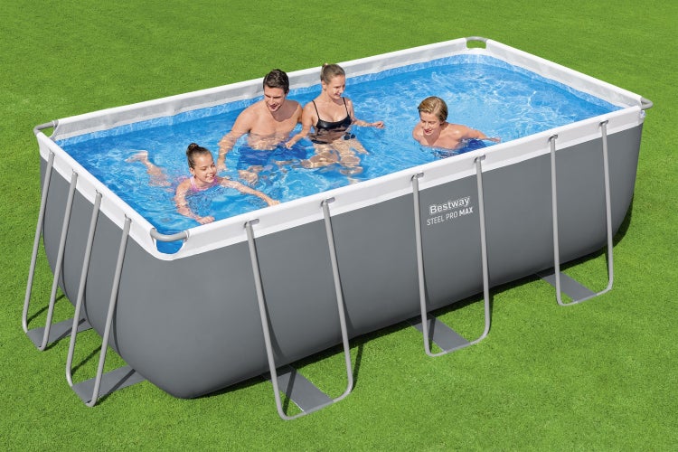 Bestway Steel Pro MAX Aufstellpool rechteckig mit grauem Stahlrahmen auf einer Rasenfläche, vier Personen baden im klaren Wasser, helle Außenaufnahme.