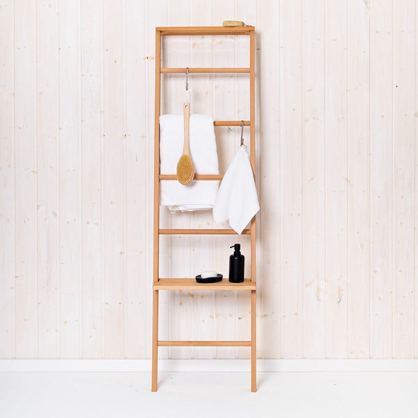 Handtuchleiter aus Holz mit Ablage für das Badezimmer, bestückt mit Handtüchern und Badaccessoires vor einer Holzwand.