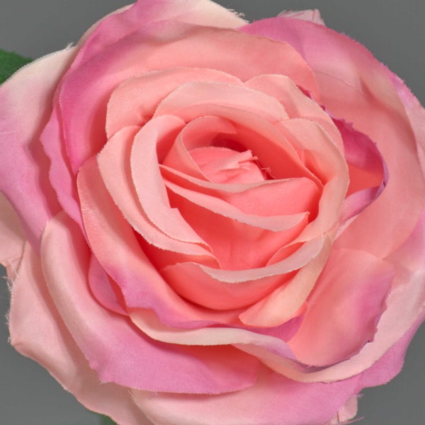 Künstliche Rosenblüte aus Textilgewebe in verschiedenen Rosatönen.