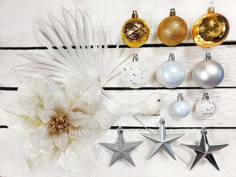 Weihnachtsdekoration Set mit Christbaumkugeln, Sternen, Kunstblume und Vogel auf Holzuntergrund