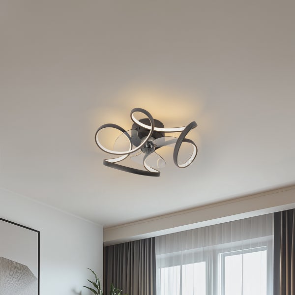 Moderner Deckenventilator mit integrierter LED-Beleuchtung in geschwungener Form und transparenten Flügeln in einem Wohnraum.
