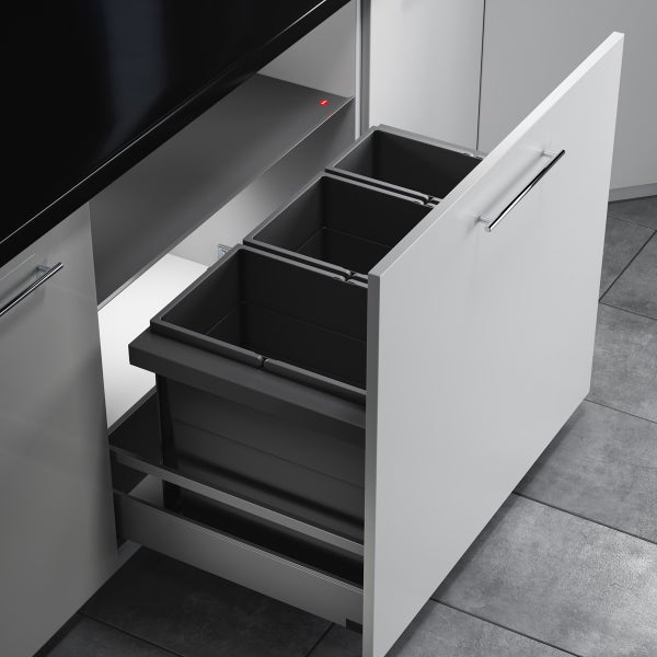 Einbau-Mülltrennsystem mit drei grauen Eimern in einer weißen Küchenschublade mit silbernem Griff unter einer schwarzen Arbeitsplatte.