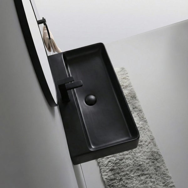 Modernes Bad mit schwarzem Waschbecken, Einhebelmischer, Spiegel und flauschigem Badteppich in minimalistischem Design.