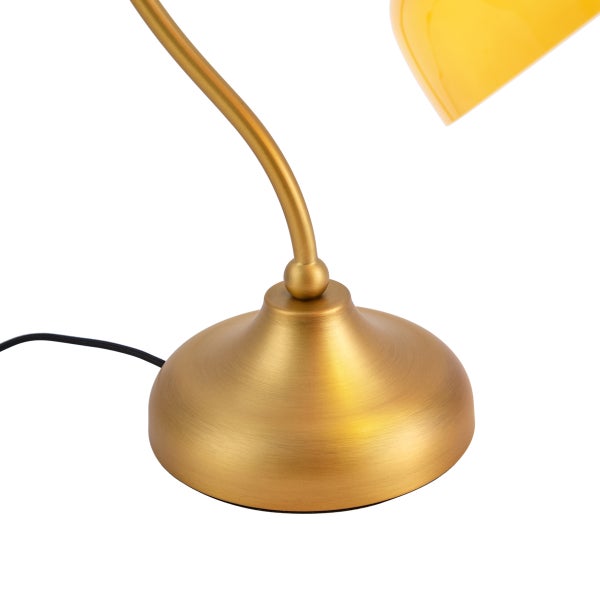 Detail einer Tischleuchte mit rundem Sockel in Messing-Optik und gebogenem Metallarm.