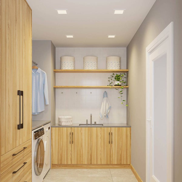 Heller, organisierter Hauswirtschaftsraum mit Schränken in Holzoptik, einer Waschmaschine, Einbauspüle und Wandregalen vor einem Fliesenspiegel.