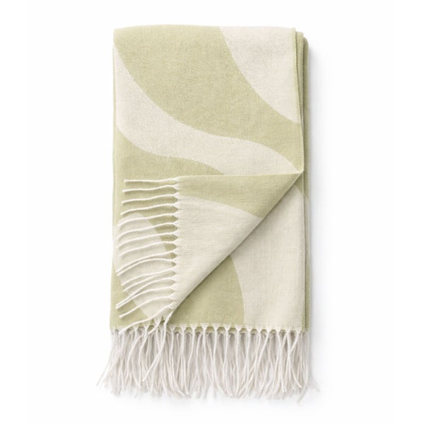 Gefaltete Wohndecke mit großem Wellenmuster und weißen Fransen am unteren Ende.