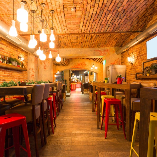 Grüner Ampelschirm mit dunklem Metallgestell und Kreuzfuß.