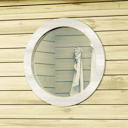 Rundfenster eingebaut in eine Holzwand eines Gartenhauses.