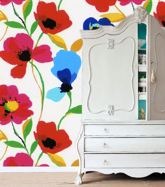 Dekoratives Zimmer mit blumiger Tapete und weißem Schrank