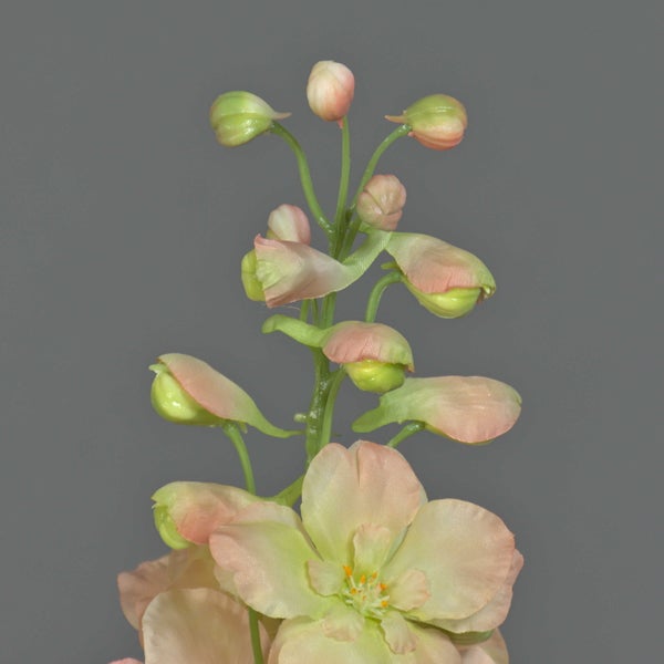 Weiße künstliche Orchidee Phalaenopsis in grauem Keramiktopf mit Blättern und Stützstäben.