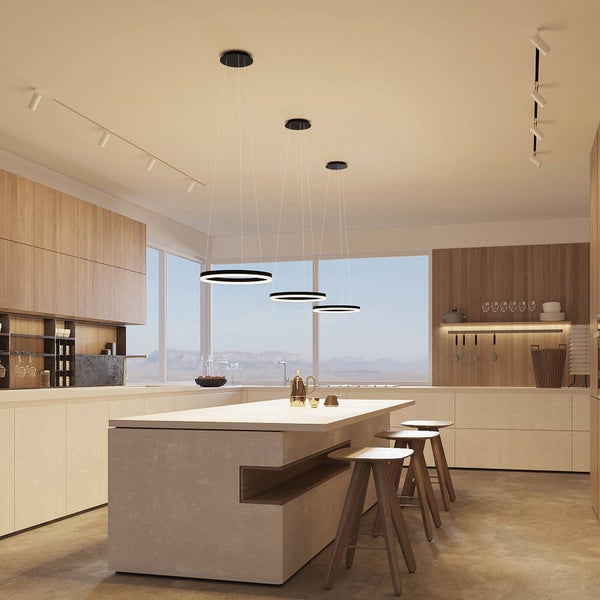 Moderne Küche mit drei runden schwarzen LED-Pendelleuchten über einer hellen Kücheninsel mit Barhockern aus Holz und Bergblick.