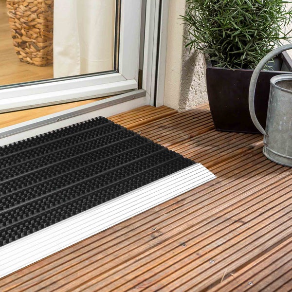 Schwarze Eingangsmatte mit Aluminiumprofil auf Holzterrasse