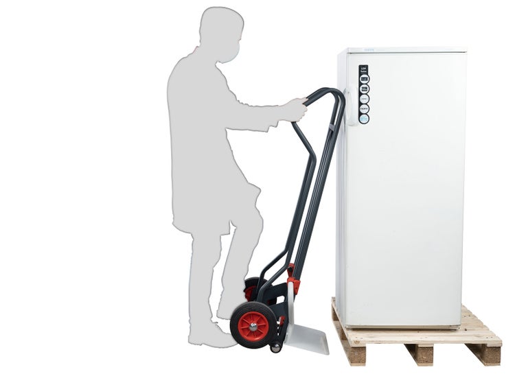 Sackkarre beim Transport eines großen Elektrogeräts auf einer Palette, silhouettierte Person bedient die Transporthilfe.