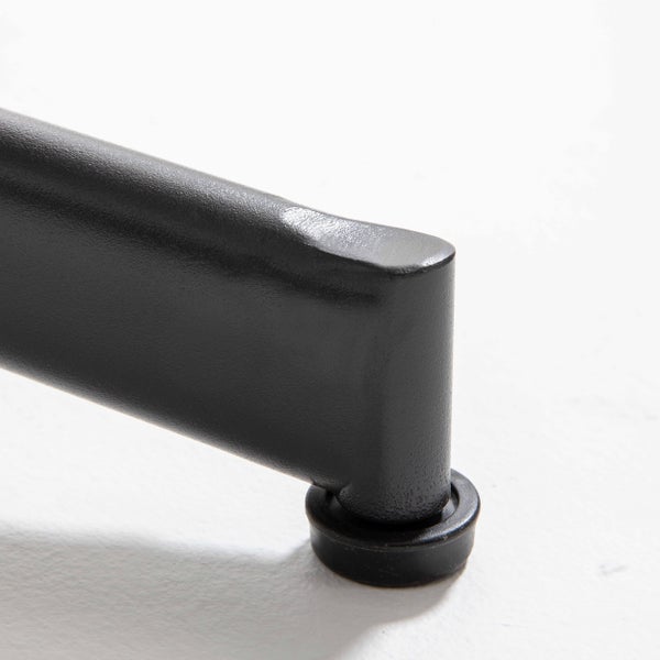 Nahaufnahme eines schwarzen Möbelfußes aus Metall mit einem Bodengleiter aus Kunststoff zum Schutz des Fußbodens.