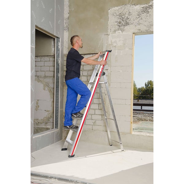 Eine Person benutzt eine Aluminium-Doppelleiter in einem Rohbau