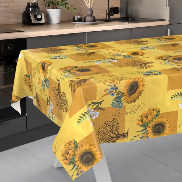 Gelbe Tischdecke mit Sonnenblumen-Muster und dem Schriftzug Le Soleil in einer modernen, hellen Küche.