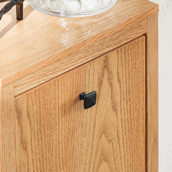 Detailaufnahme eines Holzschranks mit dunklem, quadratischem Griff.