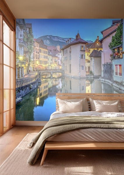 Fototapete mit abendlicher Stadtansicht über einem Bett